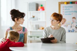 Young mom talking with therapist about her autistic son
