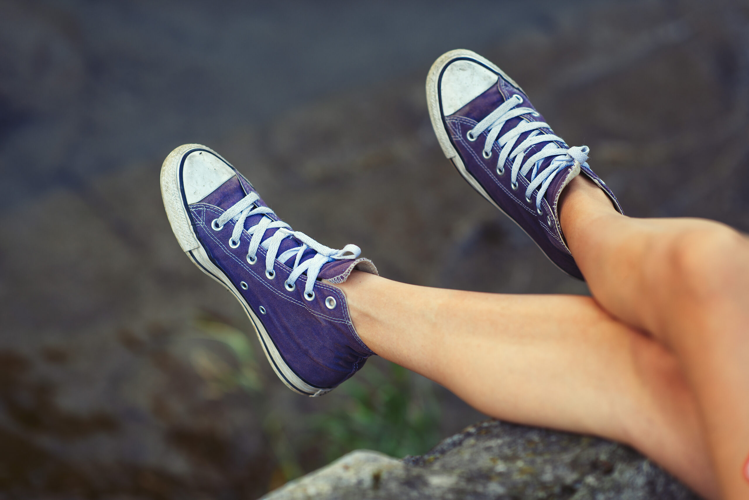 Legs of girl with sneakers.